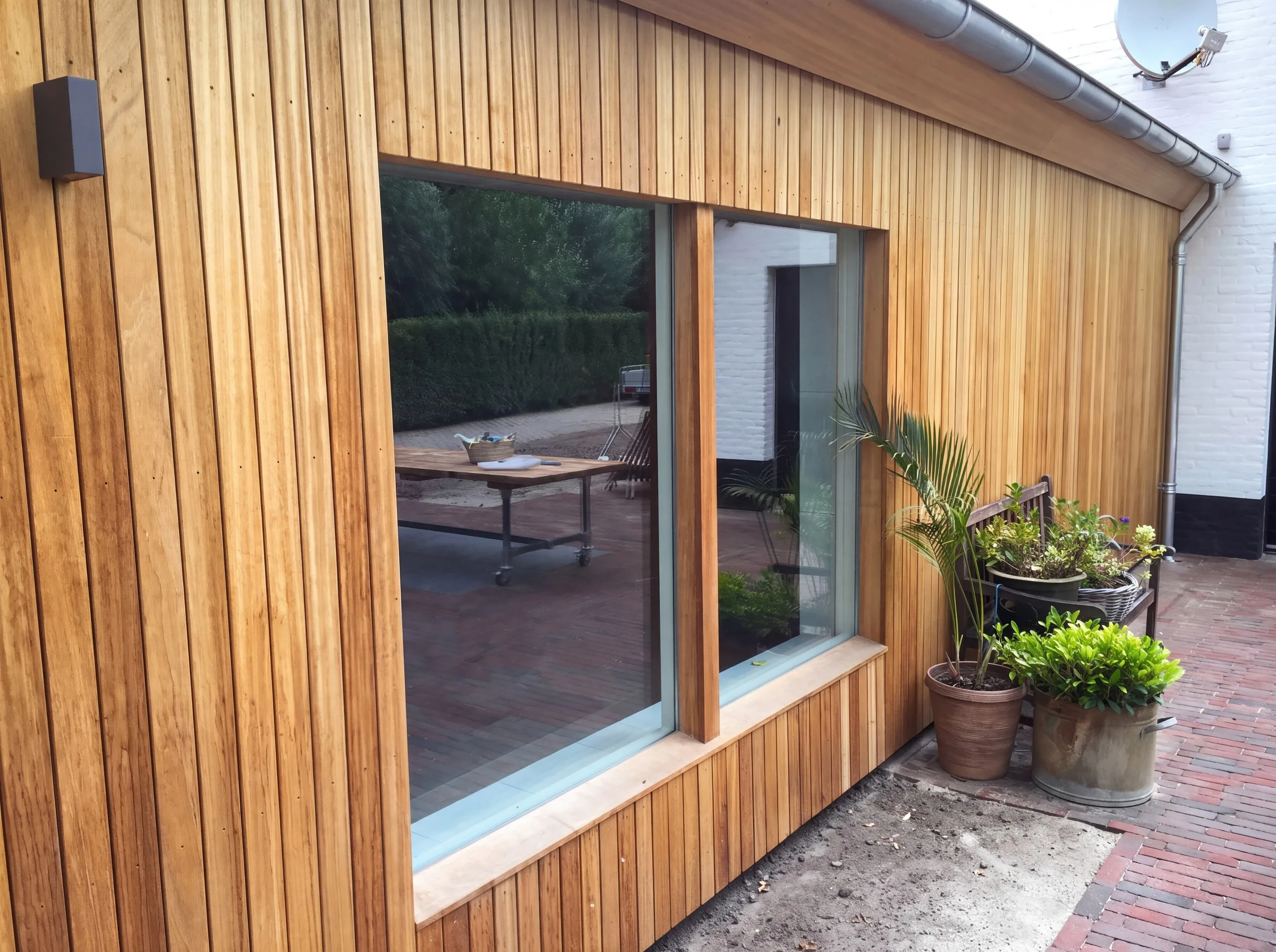 Gevelbekleding van thermisch gemodificeerd hout naast een raam